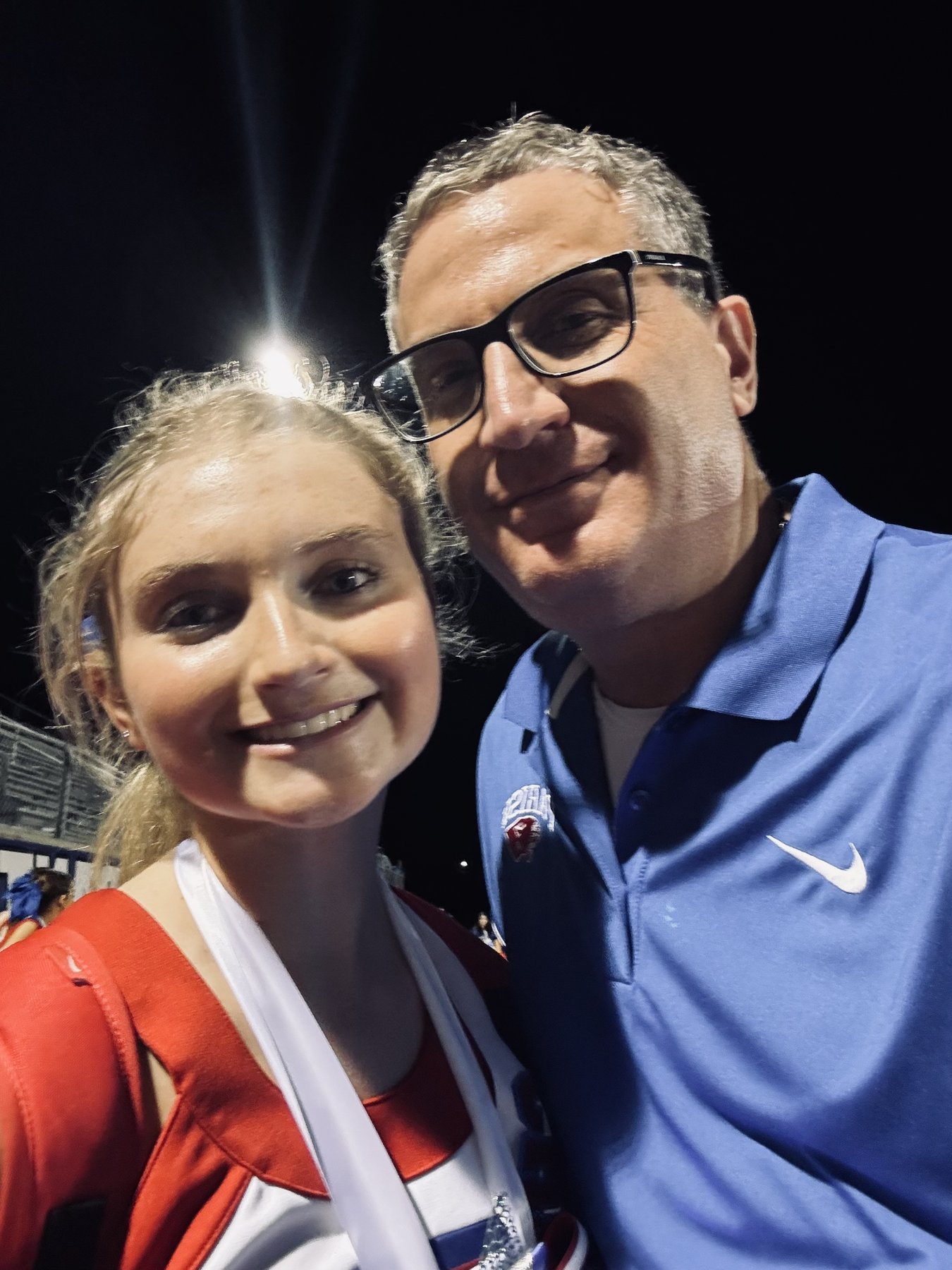 Andrew Hillman with a companion at a stadium at night. Night stadium selfie.